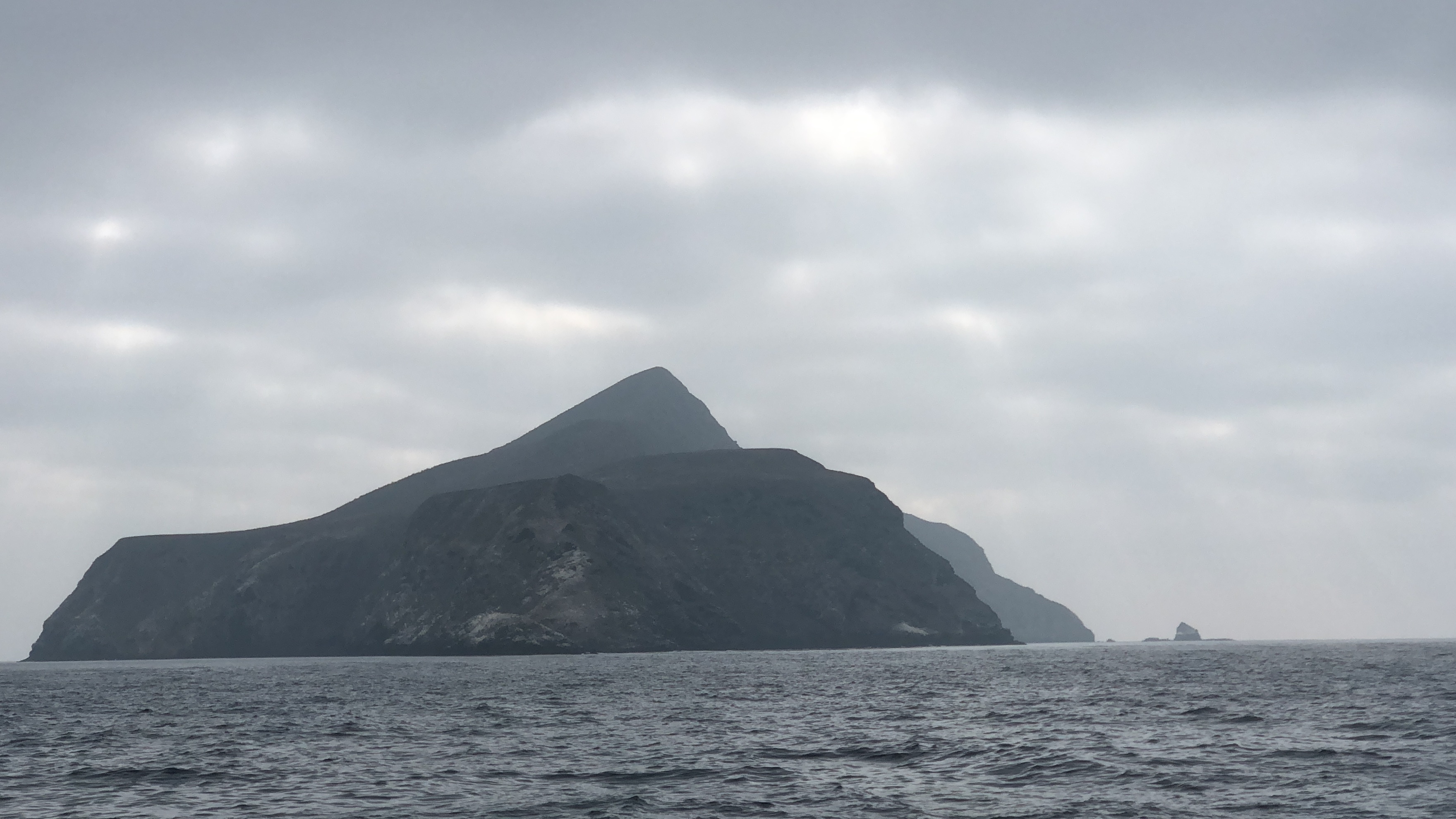 Anacapa Island rising from the marine layer with its distinctive pyramid shape and offshore islet