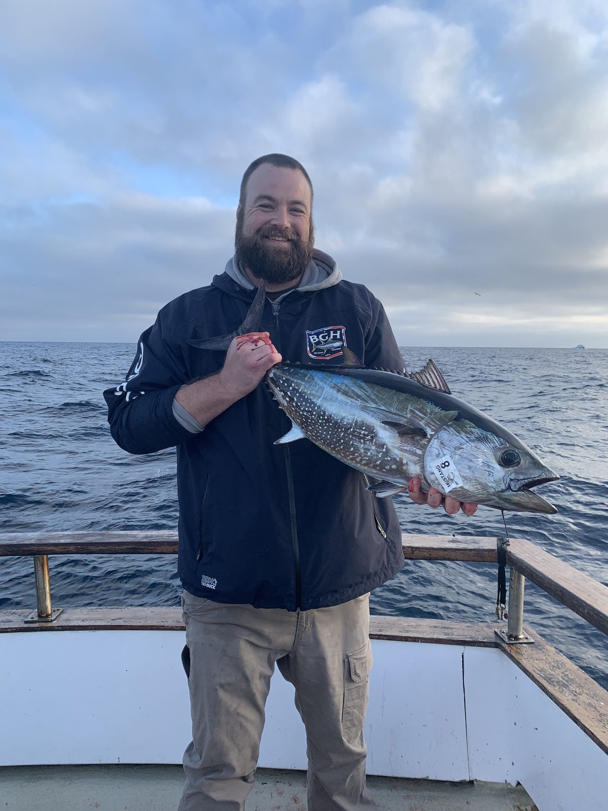 An angler aboard a San Diego boat holds up a bluefin tuna caught on an offshore run