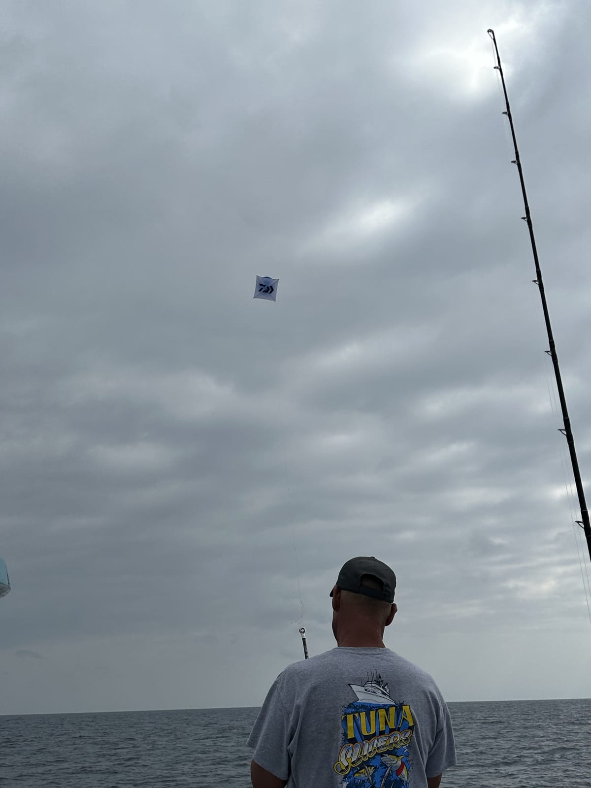 An angler working a fishing kite off the rail on an offshore SoCal bluefin trip