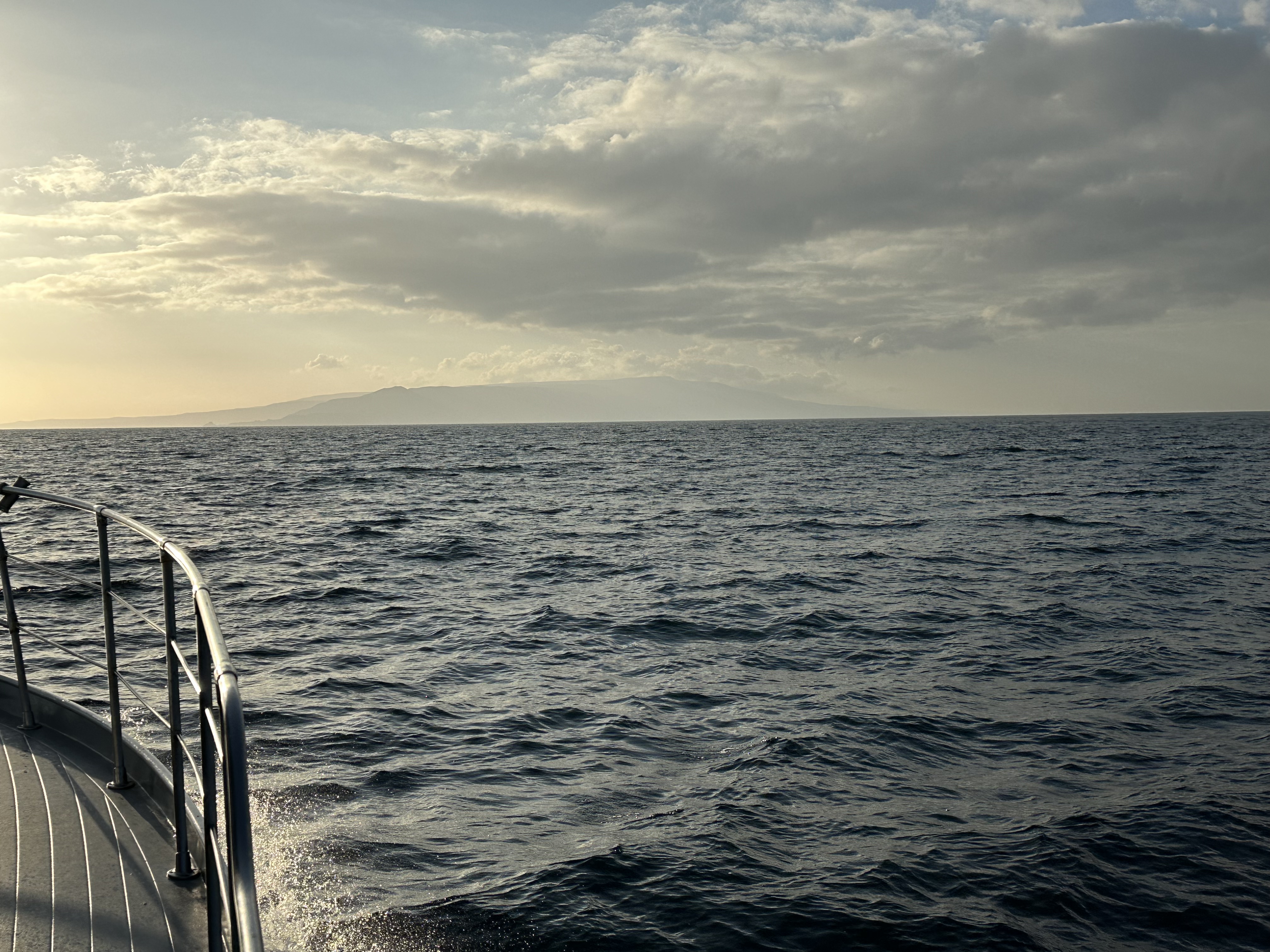 Catalina Island low on the horizon seen from the bow rail at golden hour